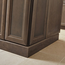 Close up of baseboard moulding on gray-brown cabinets