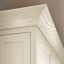 Cove crown moulding on painted white oak cabinets