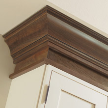 Off white cabinets with dark brown stained cabinet moulding