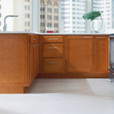 L shape configuration of base cabinets in a medium wood finish