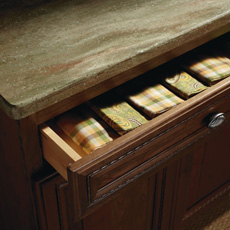 Cabinet drawer partially open to show linens inside
