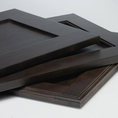 Stack of recessed panel cabinet doors in dark wood tones