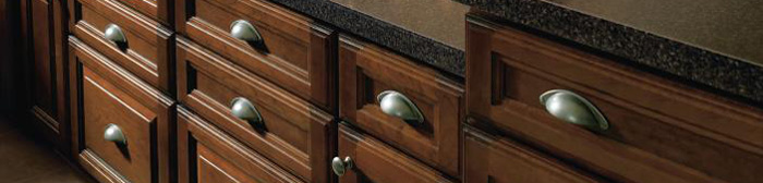Close-up of base cabinets in a medium brown wood stain with cup pulls