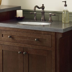 Vanity cabinet with bronze cabinet pulls and matching faucet