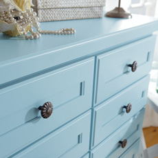 Close up of blue dresser with metal knobs
