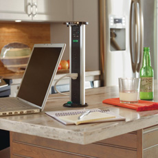 Laptop being charged on kitchen island with pop-up Sensio PowerPod